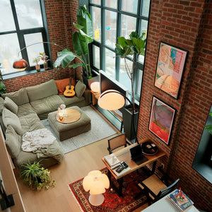 Modern living room with a brick wall, green sofa, and decorative elements.